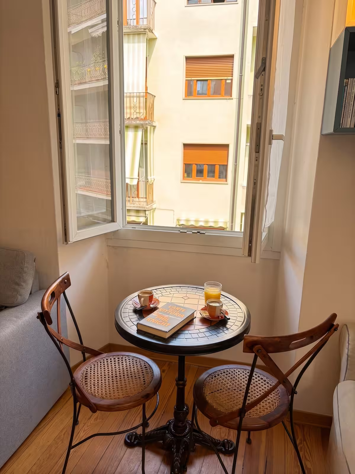 Angolo colazione dell'Appartamento Moneta a Domodossola: tavolino con caffè davanti alla finestra aperta e parquet